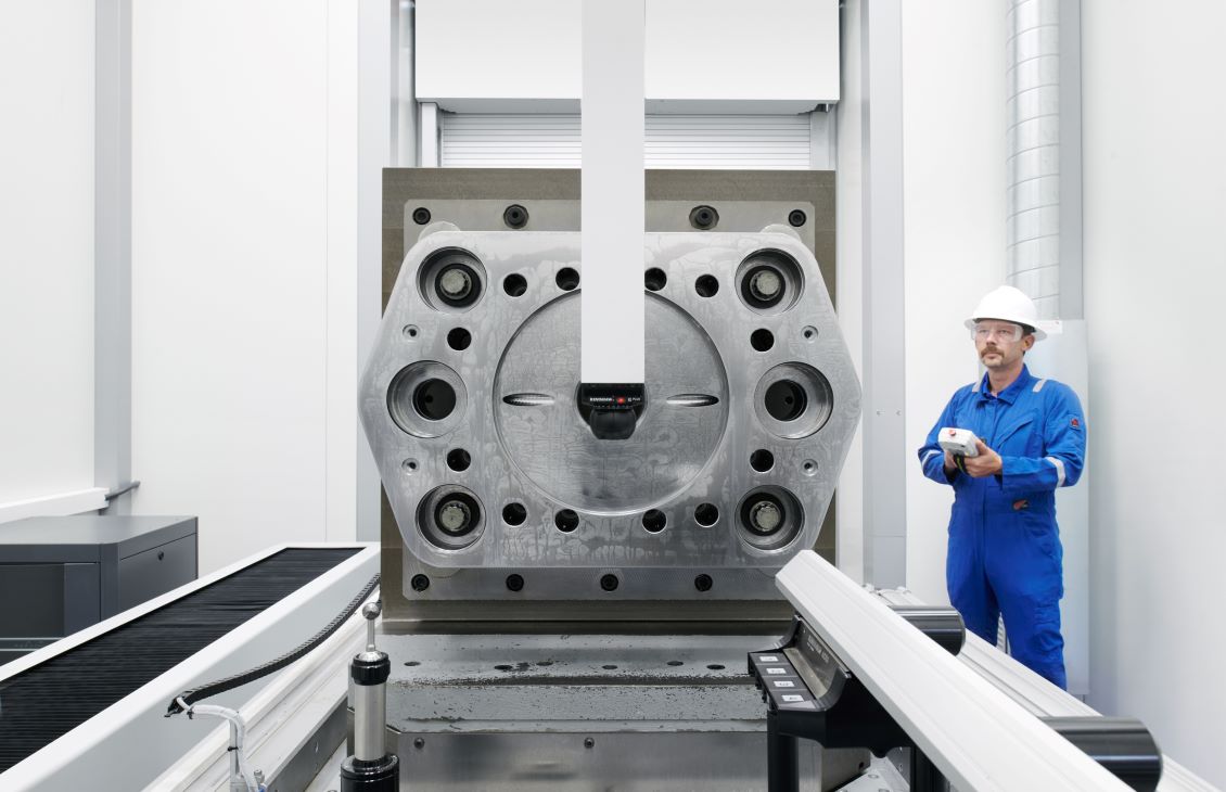 Male SLB engineer holding controls in blue coveralls