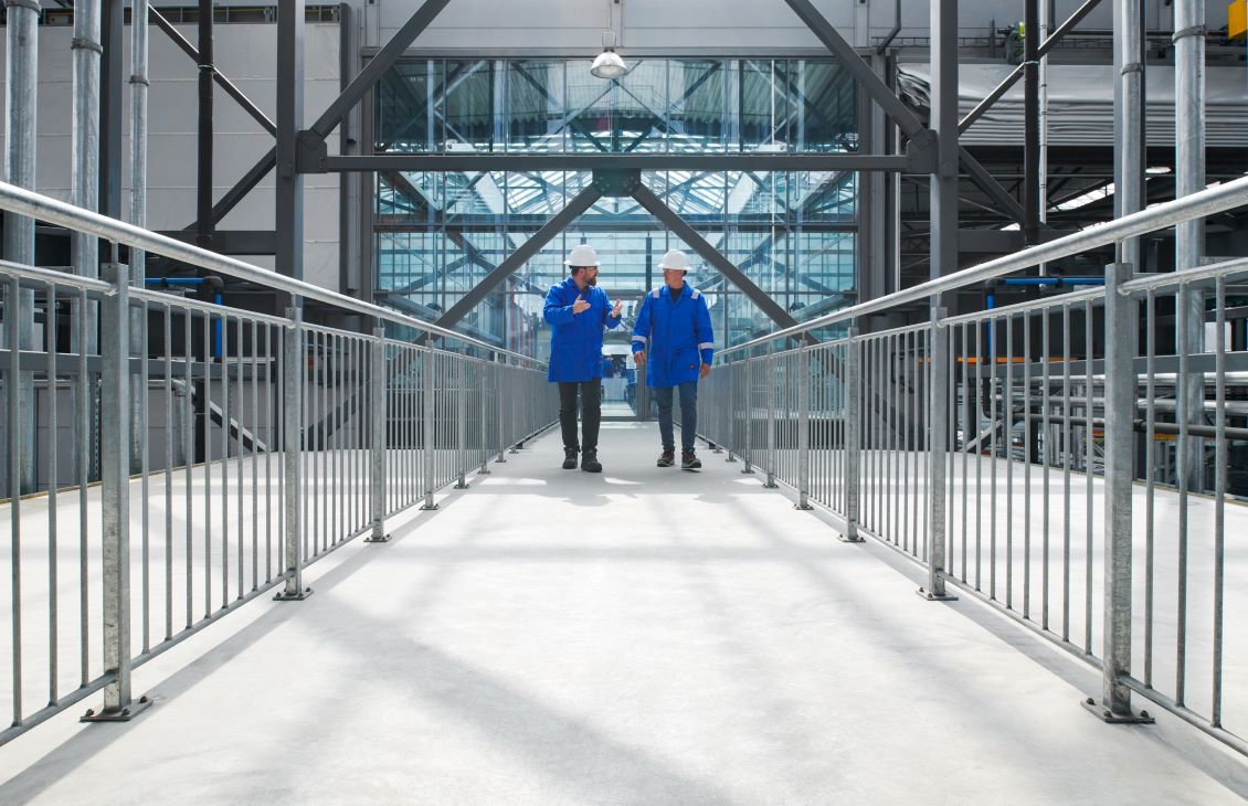 Two SLB employees walking on a bridge speaking to each other