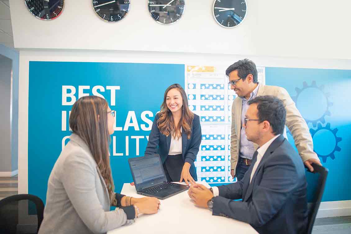 Group of office workers conferencing in front of a white board.