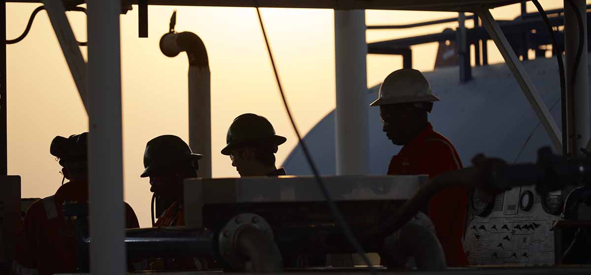 Oilfield workers gather in the field.