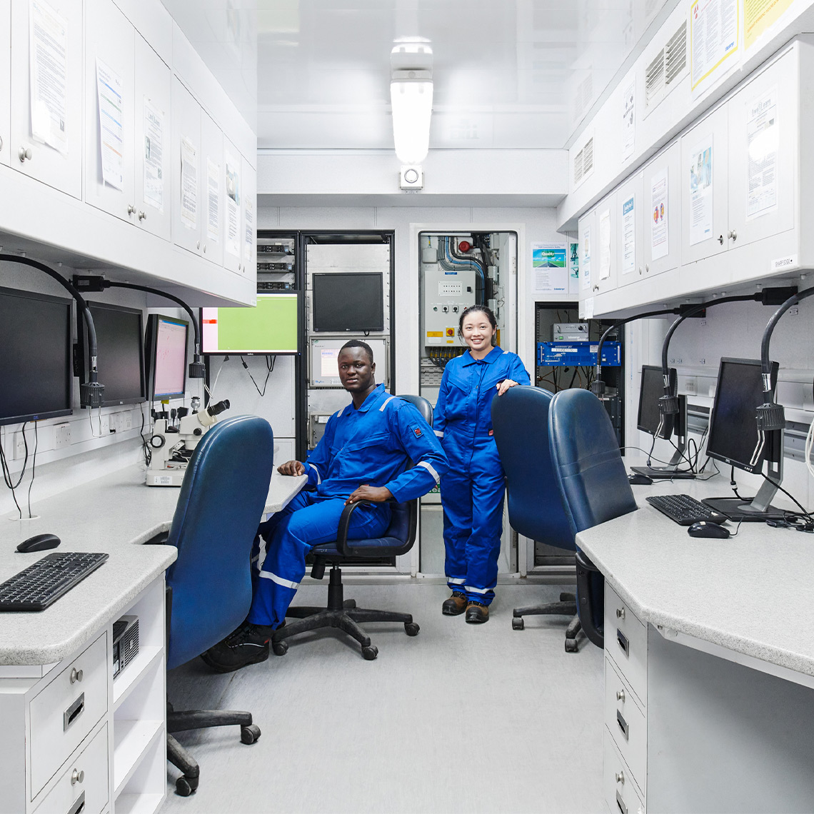Two SLB employees in a lab in front of computers
