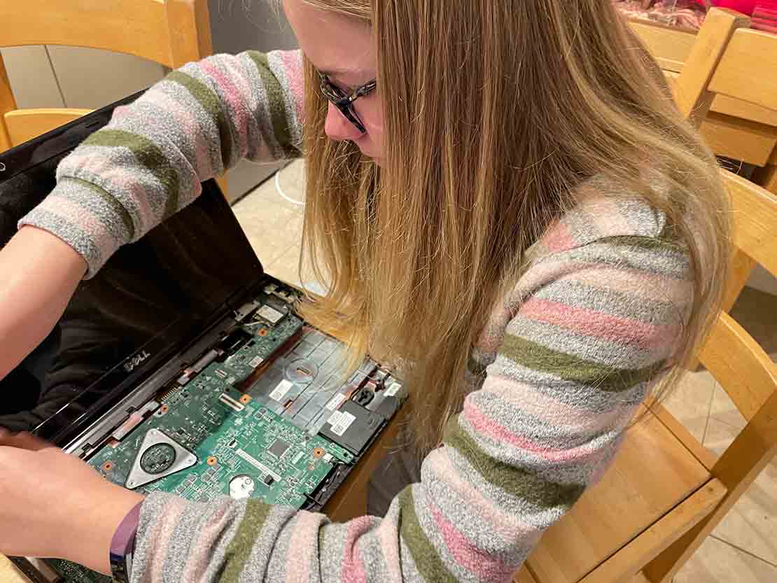 Student looking at computer hard drive equipment.