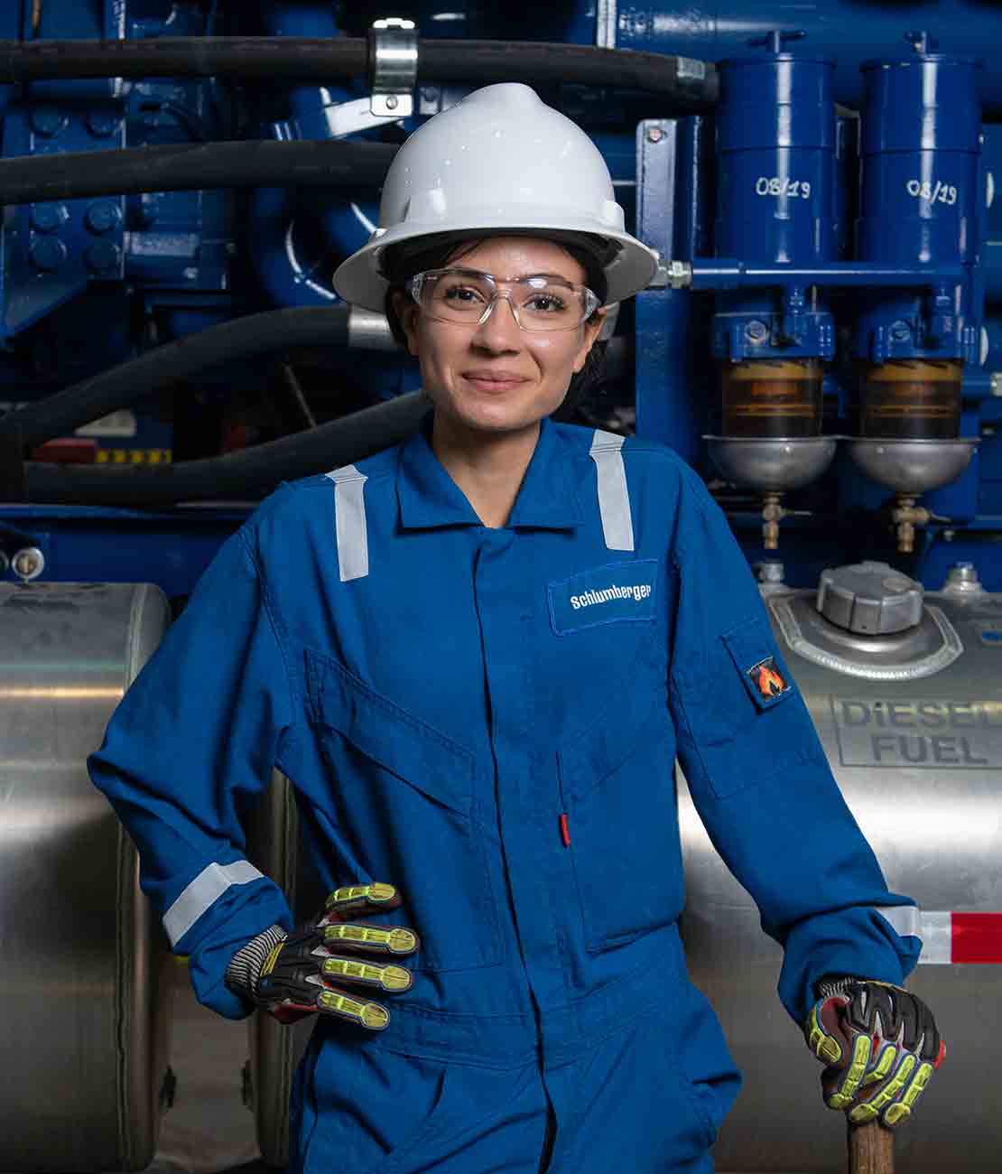 Female maintenance engineer stands in front of truck.