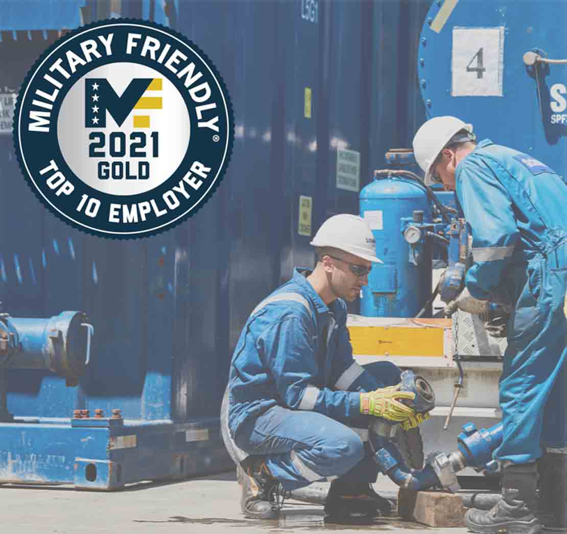 Military service member stands in front of rig.