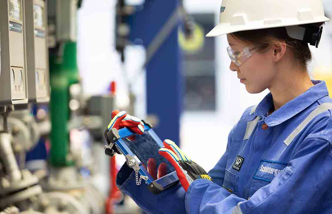 Woman with control pad at well site.