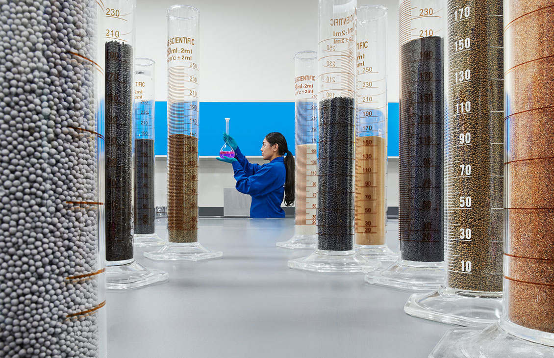 Female engineering looking at beakers with solid samples in a Learning Center, Abu Dhabi (Tier 1_LearningCenter_Abu Dhabi_MENA_ 8628)