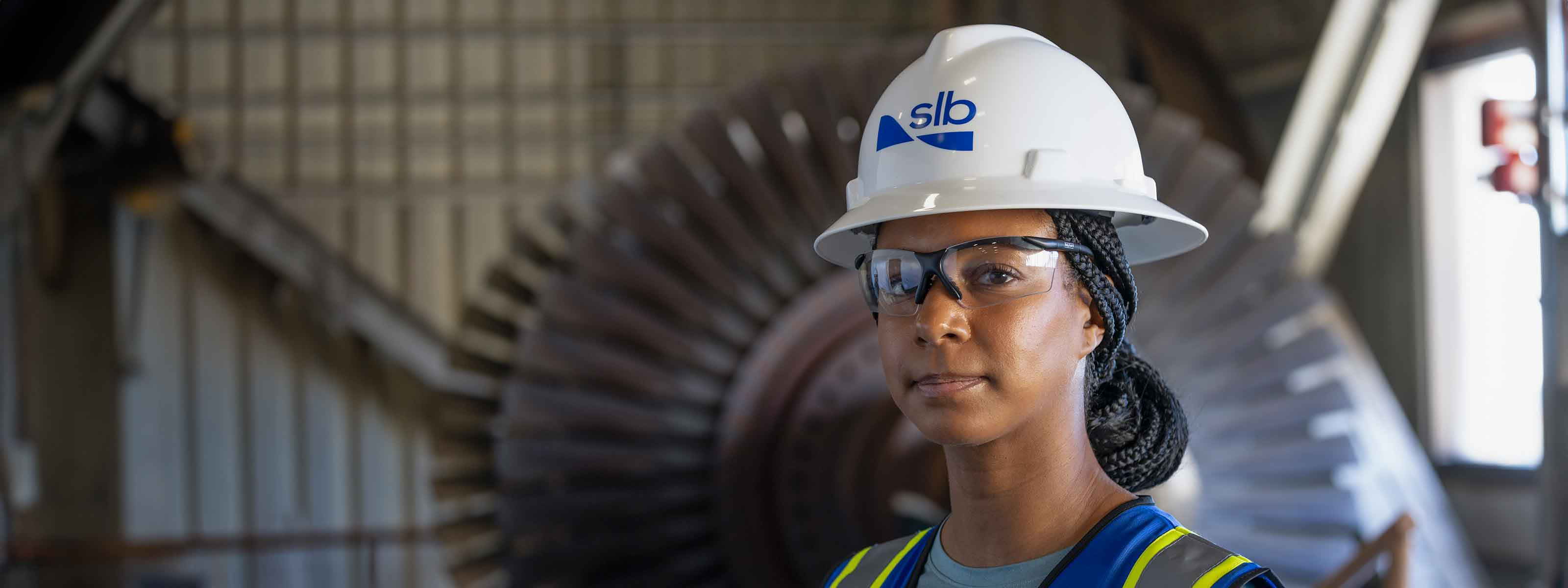 A close up of an SLB operator where a safety helmet and glasses