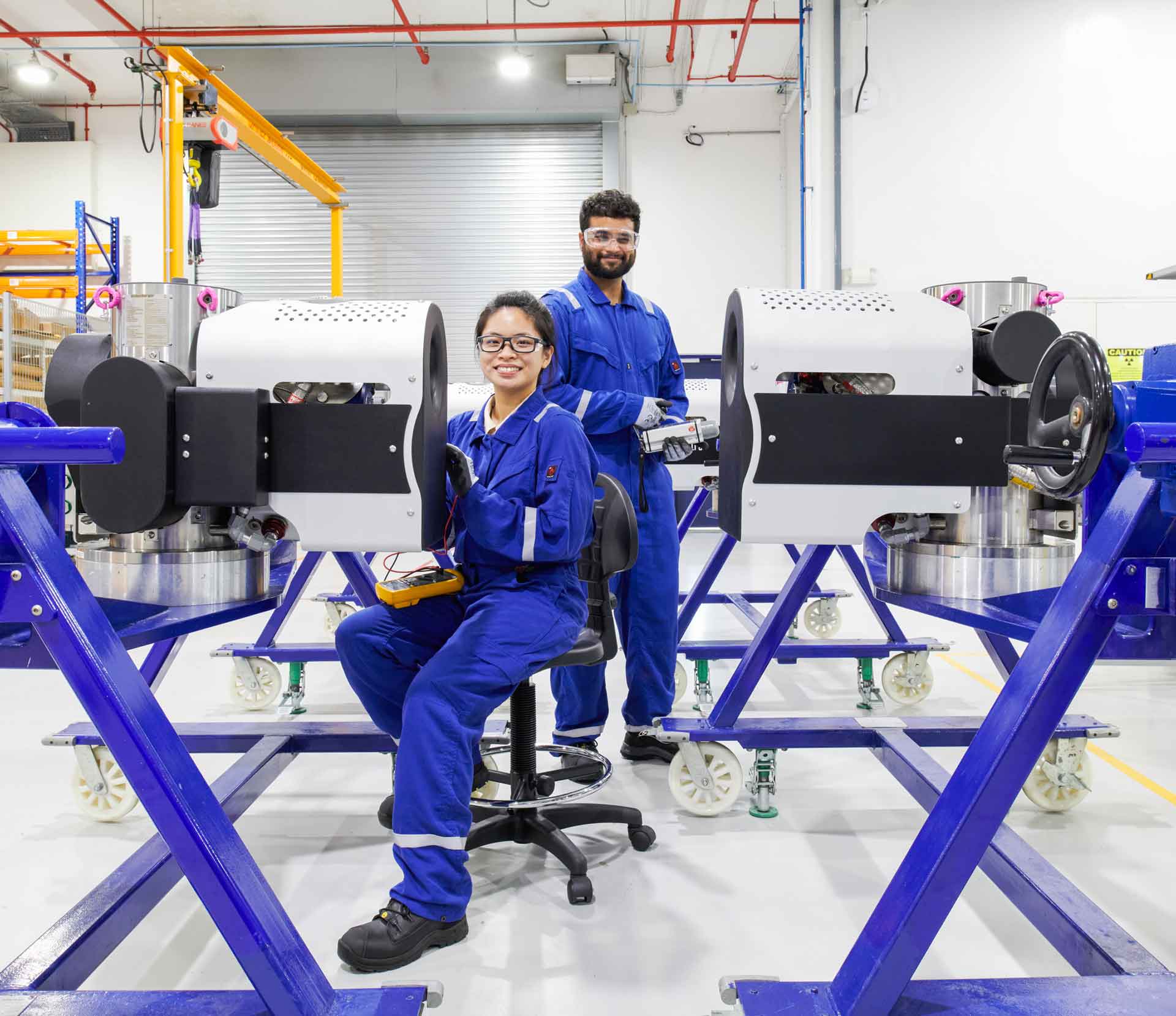 two SLB operators inspecting equipment in a manufacturing facility